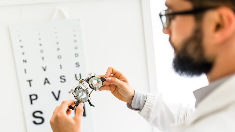 Ophthalmologist doctor looking a phoropter glasses